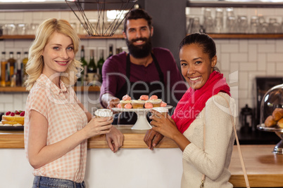 Bartender with customers holding a cup of coffee
