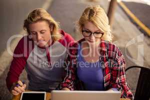 Couple using a laptop on an outdoor terrace