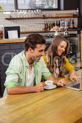 Smiling couple using a laptop