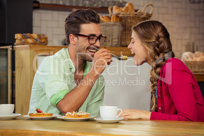 Smiling couple eating cake