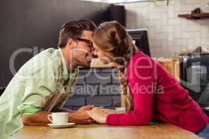 Young couple kissing each other in cafeteria