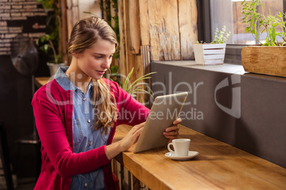 Young woman using digital tablet in cafeteria