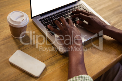 Hands typing on a laptop