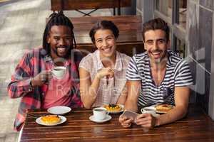 Friends drinking coffee and using smartphone