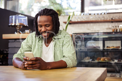 Young man using mobile phone in cafeteria