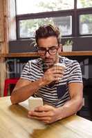 Young man using mobile phone in cafeteria