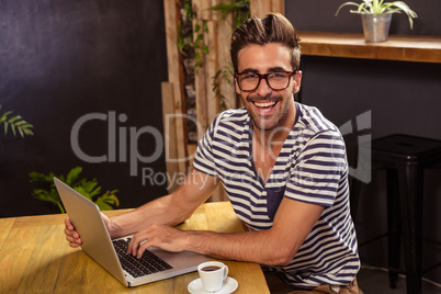 Young man using laptop in cafeteria