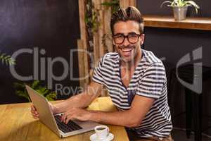 Young man using laptop in cafeteria