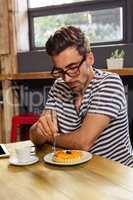 Young man having breakfast in cafeteria