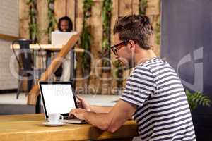 Portrait of young man sitting at table using laptop