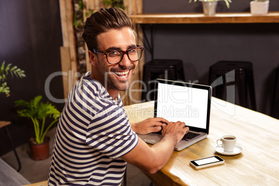 Young man using laptop in cafeteria