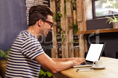 Young man using laptop in cafeteria