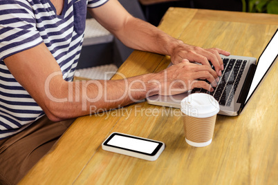 Man using laptop in cafeteria