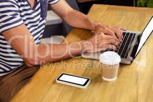 Man using laptop in cafeteria