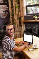 Young man using laptop in cafeteria