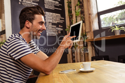 Young man using digital tablet in cafeteria