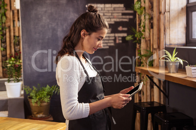 Waitress using digital tablet in cafeteria