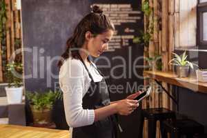 Waitress using digital tablet in cafeteria