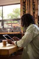 Man using digital tablet in cafeteria