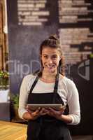 Waitress standing with digital tablet in cafeteria