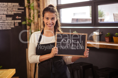 Waitress holding a sign with open