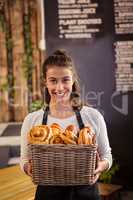 Portrait of waitress holding a basket with viennoiseries