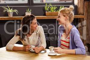 Smiling friends drinking coffee