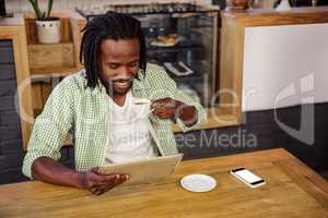 Man drinking coffee and using tablet