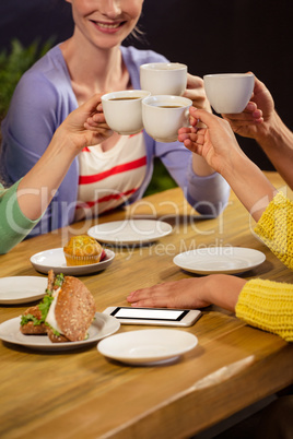 Smiling friends drinking coffee