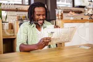 happy man laughing when is reading a newspaper