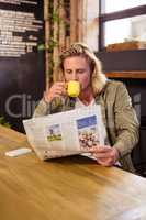 Man drinking a coffee while is reading a newspaper