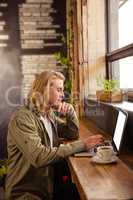 Young man using laptop in cafeteria