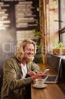 Young man using mobile phone in cafeteria