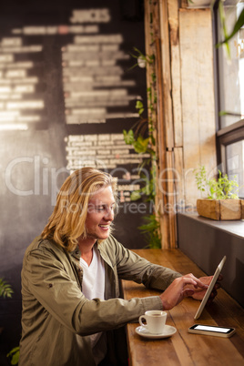 Young man using digital tablet in cafeteria