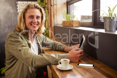 Young man using digital tablet in cafeteria