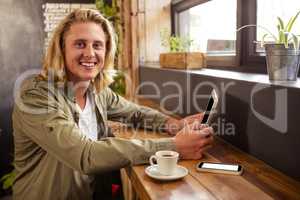 Young man using digital tablet in cafeteria