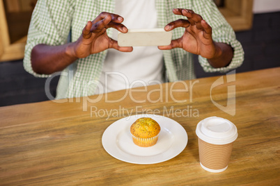 Man taking picture of a muffin