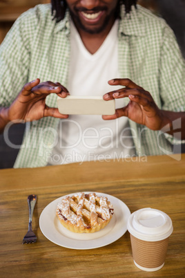 Man taking picture of a cake alone