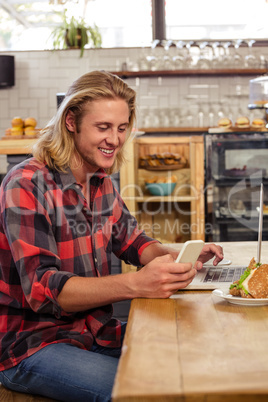 Man using smartphone and laptop