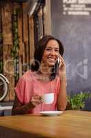 Woman drinking coffee and using smartphone