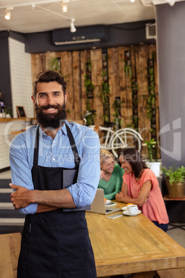 Waiter standing with arms crossed