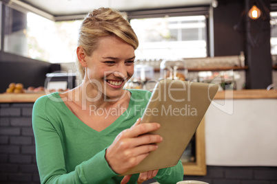 Woman using a tablet sitting and smiling