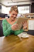 Woman using a tablet sitting and smiling