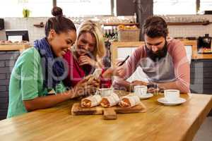 Friends using smartphones sitting