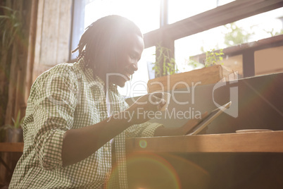 Man drinking coffee and using tablet