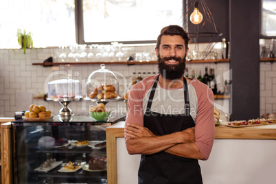 Waiter standing with arms crossed