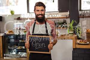 Waiter holding blackboard with open