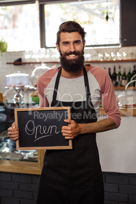 Waiter holding blackboard with open