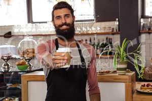 Waiter presenting a disposable cup