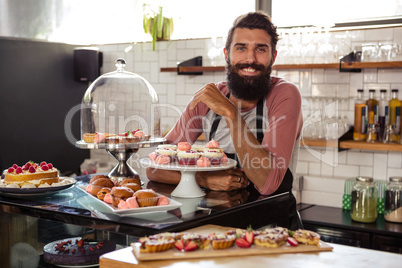 Waiter posing with cakes